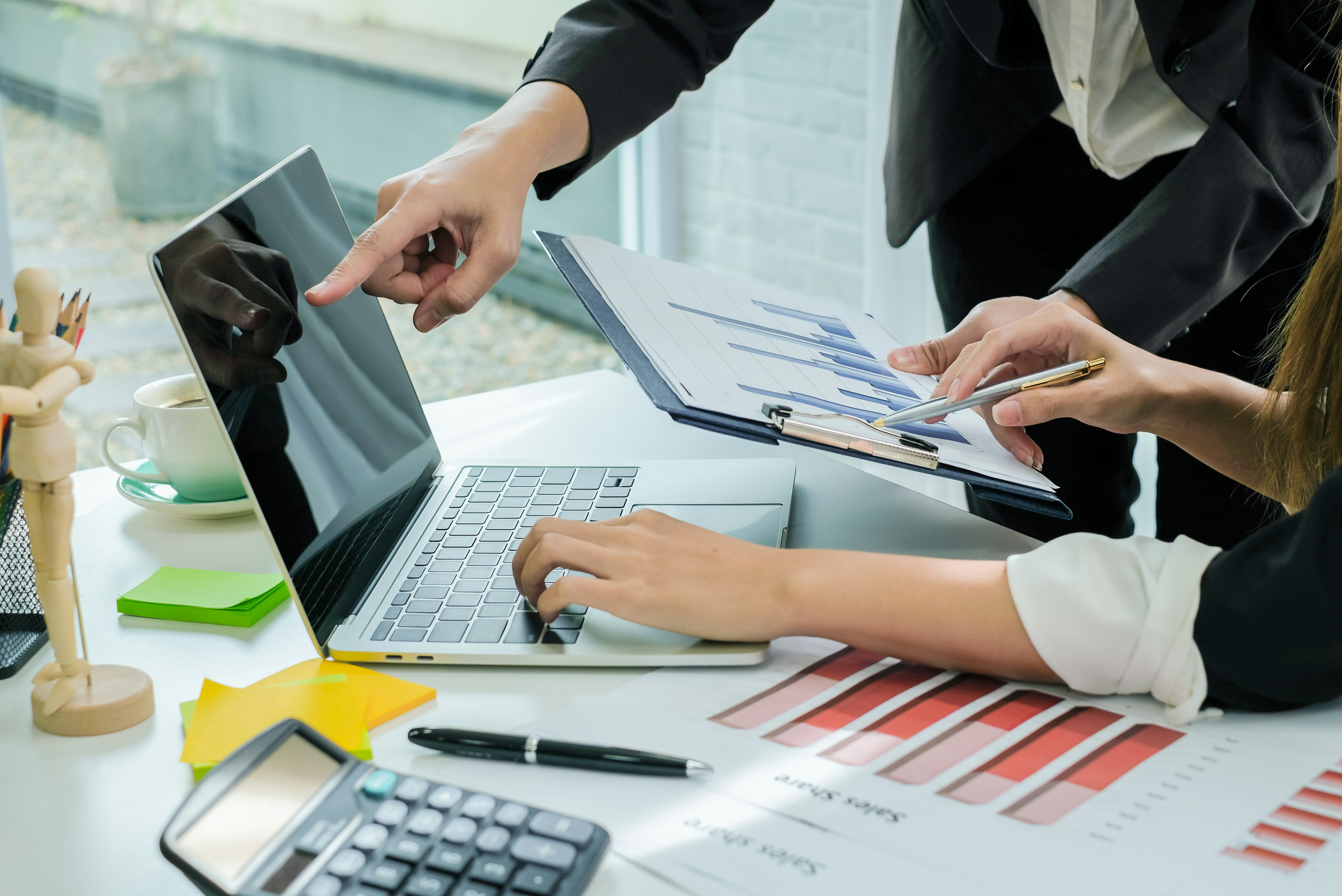 Accountants reviewing financial charts and reports on a laptop